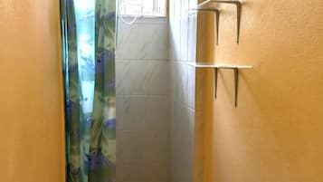 Chuveiro, toalhas de banho, sabonete, shampoo