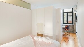 Une chambre à coucher comprenant un lit, une armoire et un bureau avec une chaise.