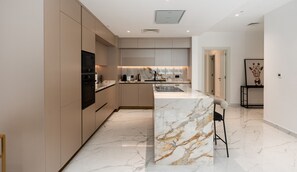Uma cozinha moderna com eletrodomésticos embutidos, ilha de mármore e design minimalista.