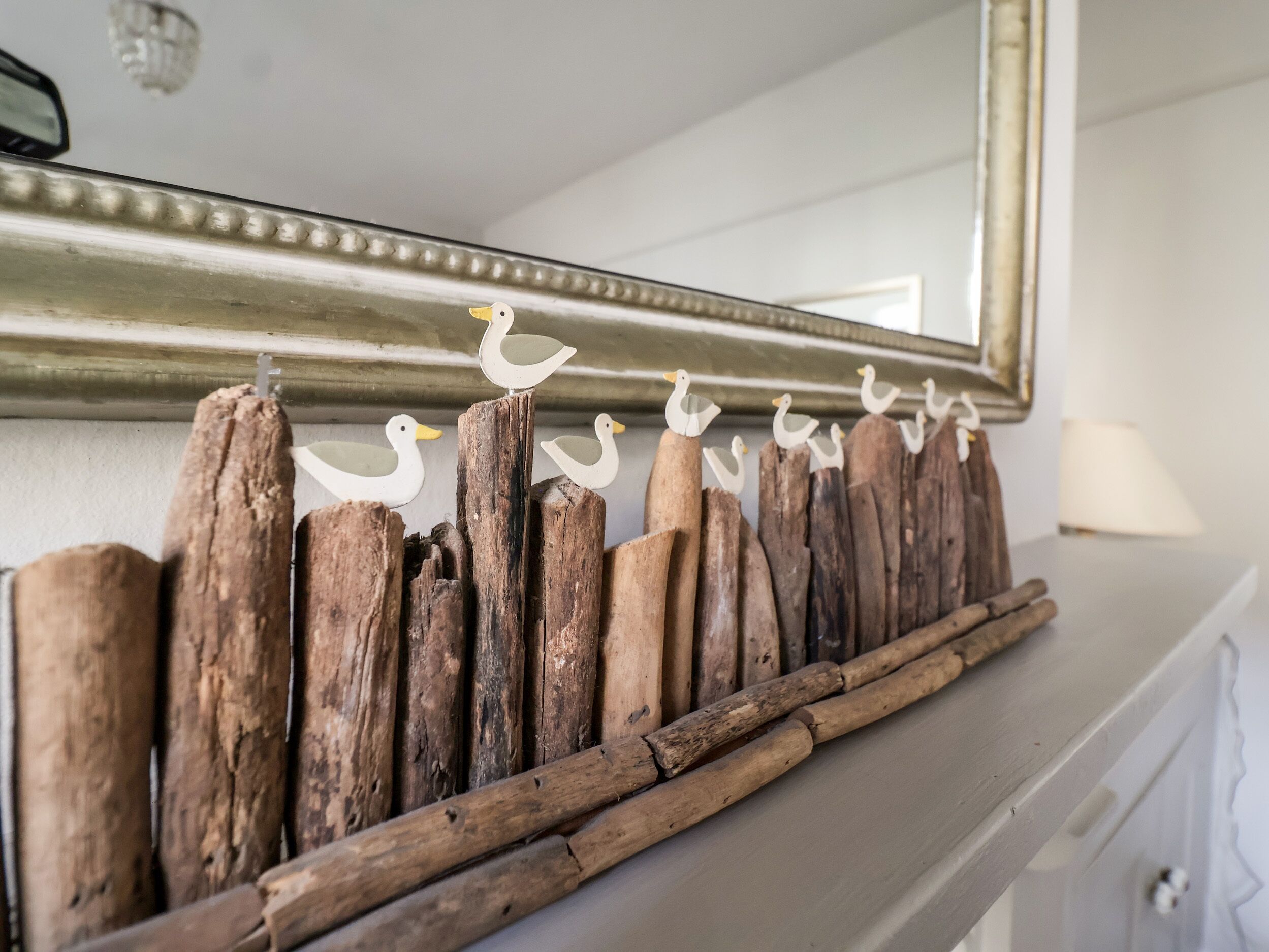 A rustic wooden shelf with decorative white duck figures.