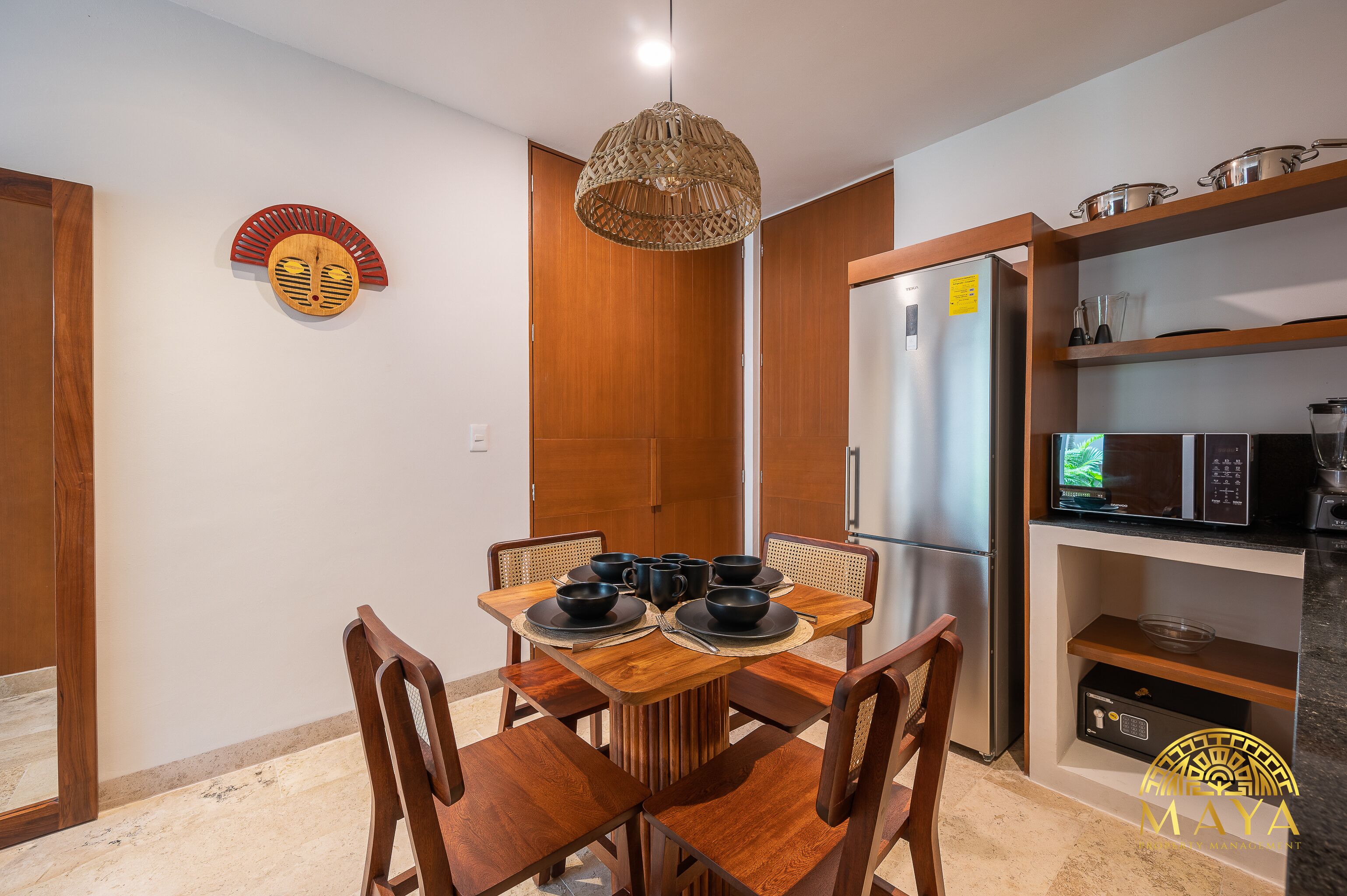 Comedor con una mesa de madera, sillas y una lámpara colgante.