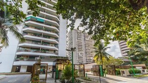 A multi-story hotel with a central courtyard, balconies, and a gated entrance. - LIBERTY PLACE - PARQUE DAS ROSAS (Rio de Janeiro)