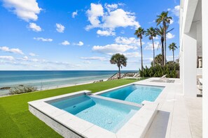 Une piscine avec vue sur l’océan et les palmiers.