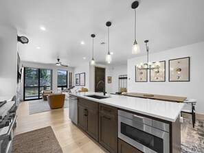 A modern kitchen with a large island, stainless steel appliances, and pendant lighting. - 541 Center Circle 3br 3.5ba 3 Bedroom Townhouse by RedAwning (Silverthorne)