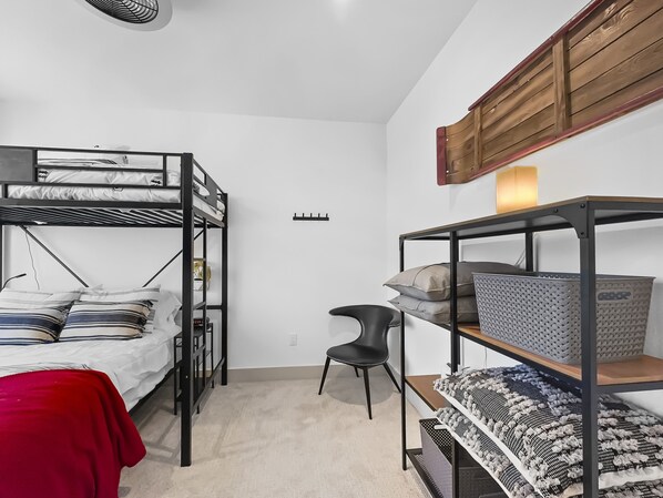 A dormitory room with bunk beds, a desk, shelves with storage boxes, and a chair. - 541 Center Circle 3br 3.5ba 3 Bedroom Townhouse by RedAwning (Silverthorne)