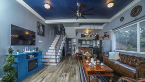 A spacious living room with a staircase, a dining area, and a kitchen. - Eagles Wings Abode (Coonoor)