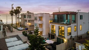Un edificio residencial de varios pisos con balcones, una zona de piscina y vistas al océano.