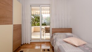 A bedroom with a bed, a wooden headboard, a sliding glass door to a balcony, and a view of greenery outside. - Apartments Bungavilia (Rovinj)
