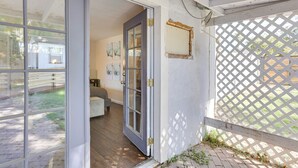 A room with a sliding glass door leading to a patio area, a white lattice fence, and a small garden. - 5 Mi to Dtwn: Pet-friendly Phoenix Studio w/ Yard (Phoenix)