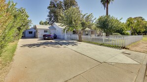 A residential property with a driveway, a white picket fence, and a parked car. - 5 Mi to Dtwn: Pet-friendly Phoenix Studio w/ Yard (Phoenix)