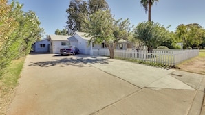 A residential property with a driveway, a white picket fence, and a parked car. - Modern Tiny Home ~ 5 Mi to Downtown Phoenix! (Phoenix)