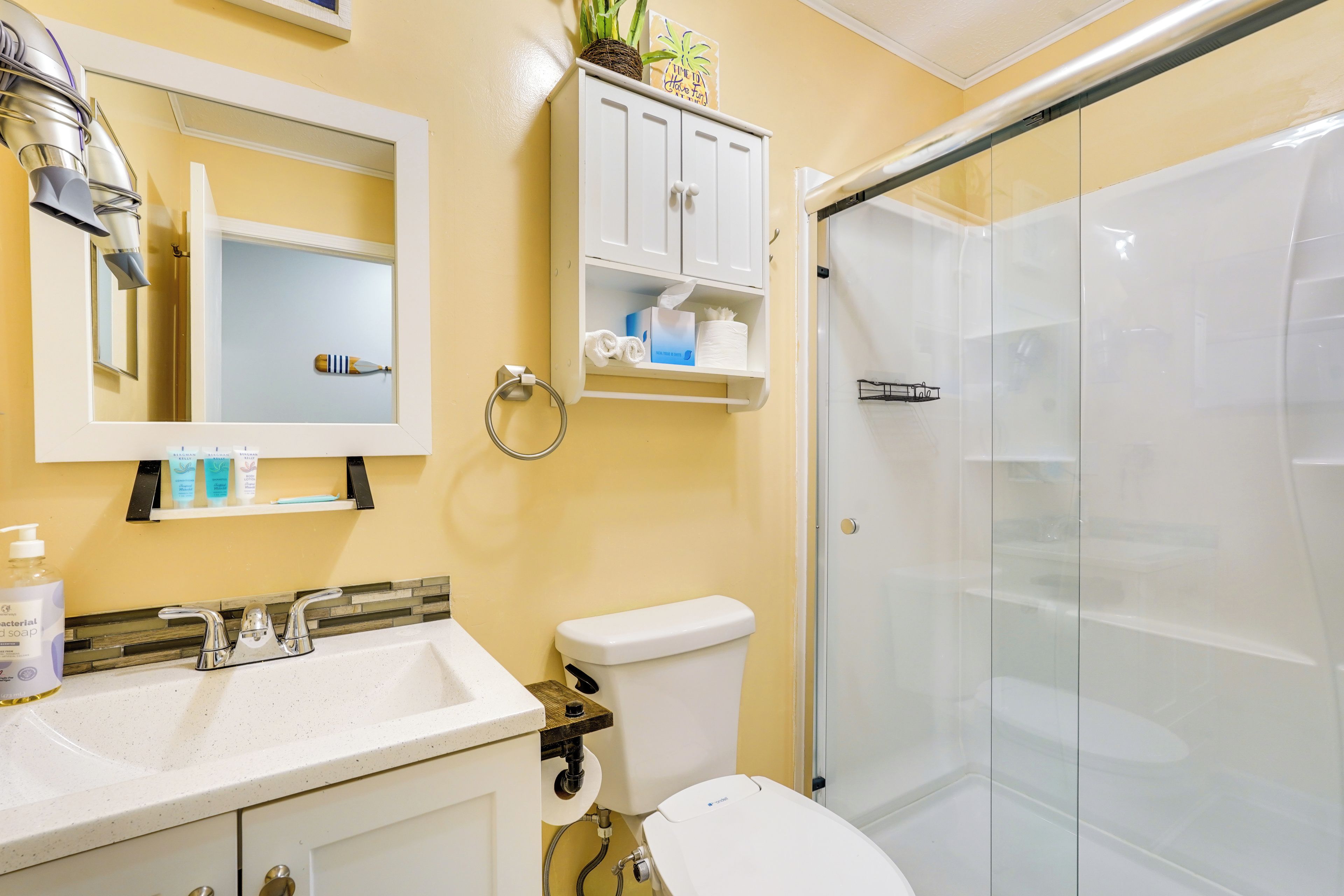 Ein Badezimmer mit Waschbecken, Toilette und Duschkabine aus Glas.