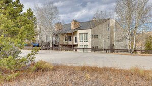 A two-story building with a stone facade, large windows, and a wooden deck. - 1/2 Mi to Granby Ranch: Townhome w/ Fireplace! (Granby)