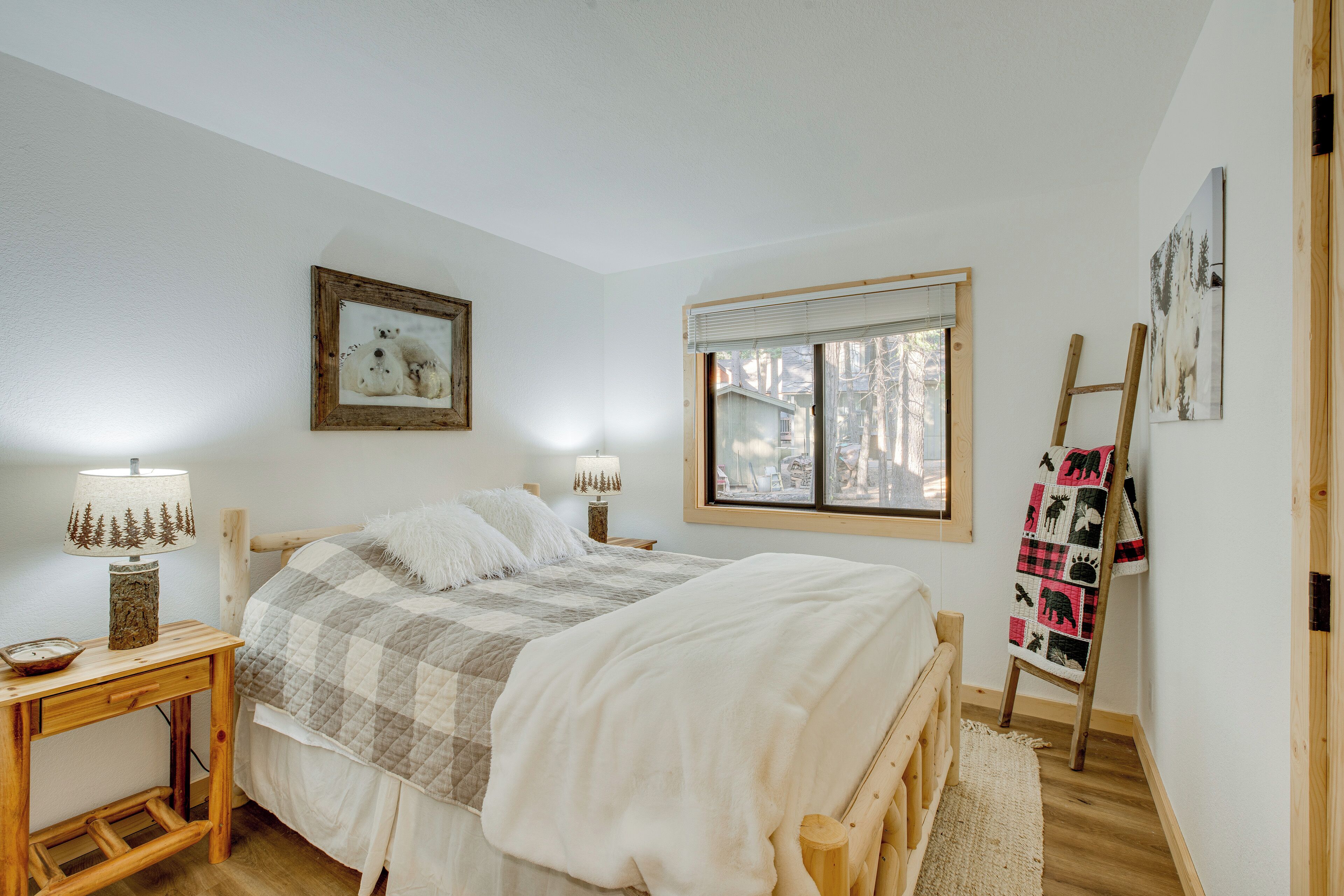 Une chambre à coucher avec un lit, des tables de chevet, une fenêtre et un tableau au mur.