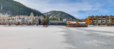 Et hotel med flere bygninger, et skiområde i baggrunden og et sneklædt landskab.