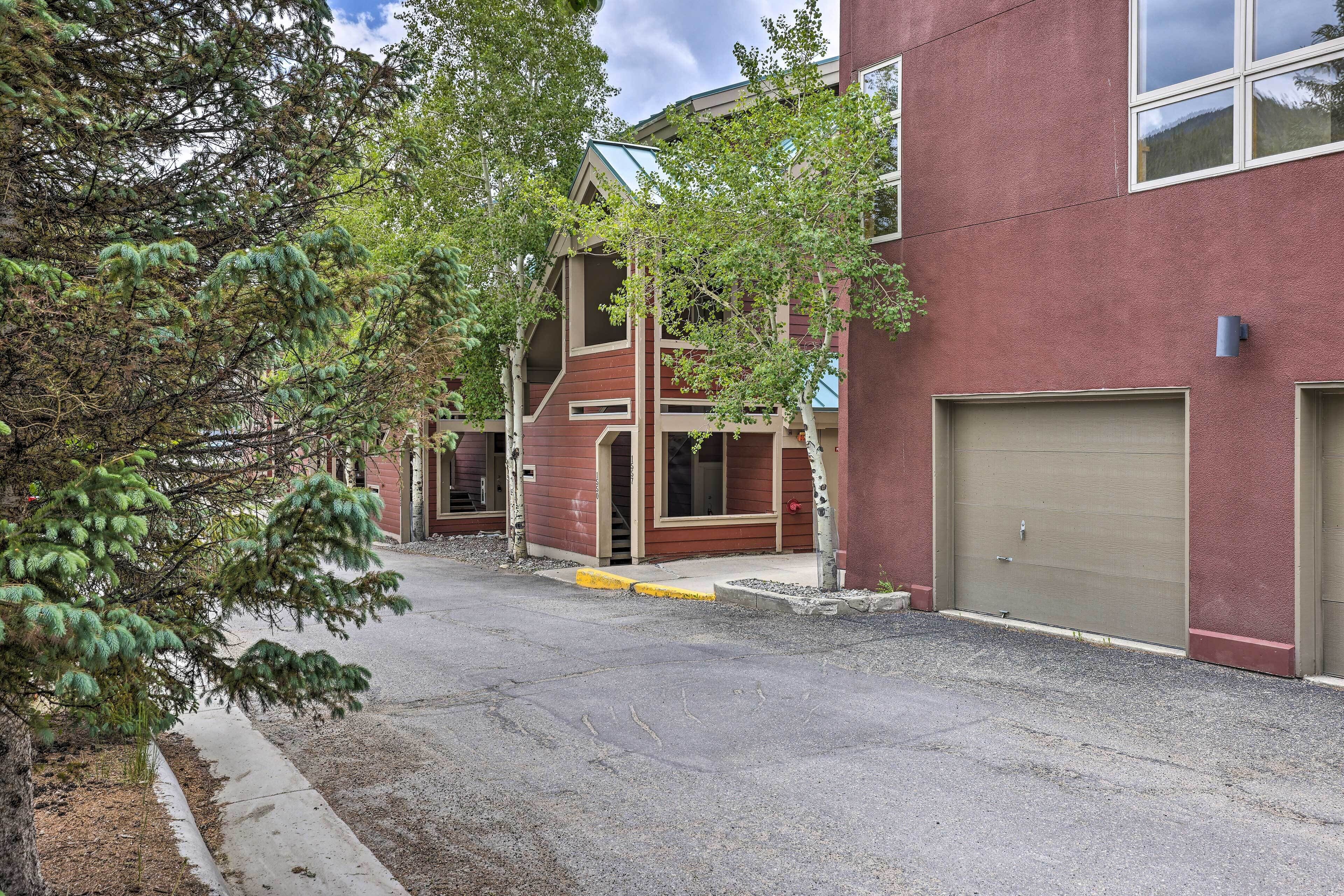 A building with a red facade, multiple garage doors, and a tree in the foreground.