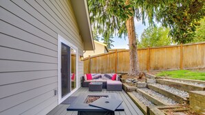 A deck with a seating area, a fire pit, and a wooden fence. - Private Yard & Fire Pit! Modern Kirkland Abode (Kirkland)