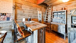 Un'accogliente interni in legno con un angolo bar, scaffali in legno e una scala.