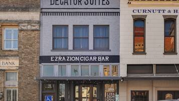 A building with a sign for 'Degatur Suites' and 'Ezra Zion Cigar Bar' on the ground floor.
