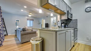 A modern kitchen with a central island, built-in cabinets, and a microwave. - Walkable Calabash Condo w/ Pool Access! (Calabash)