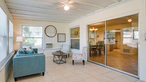 A spacious living area with a sofa, armchair, and a small table. - Pet-friendly Englewood Home - 4 Mi to Beach! (Englewood)