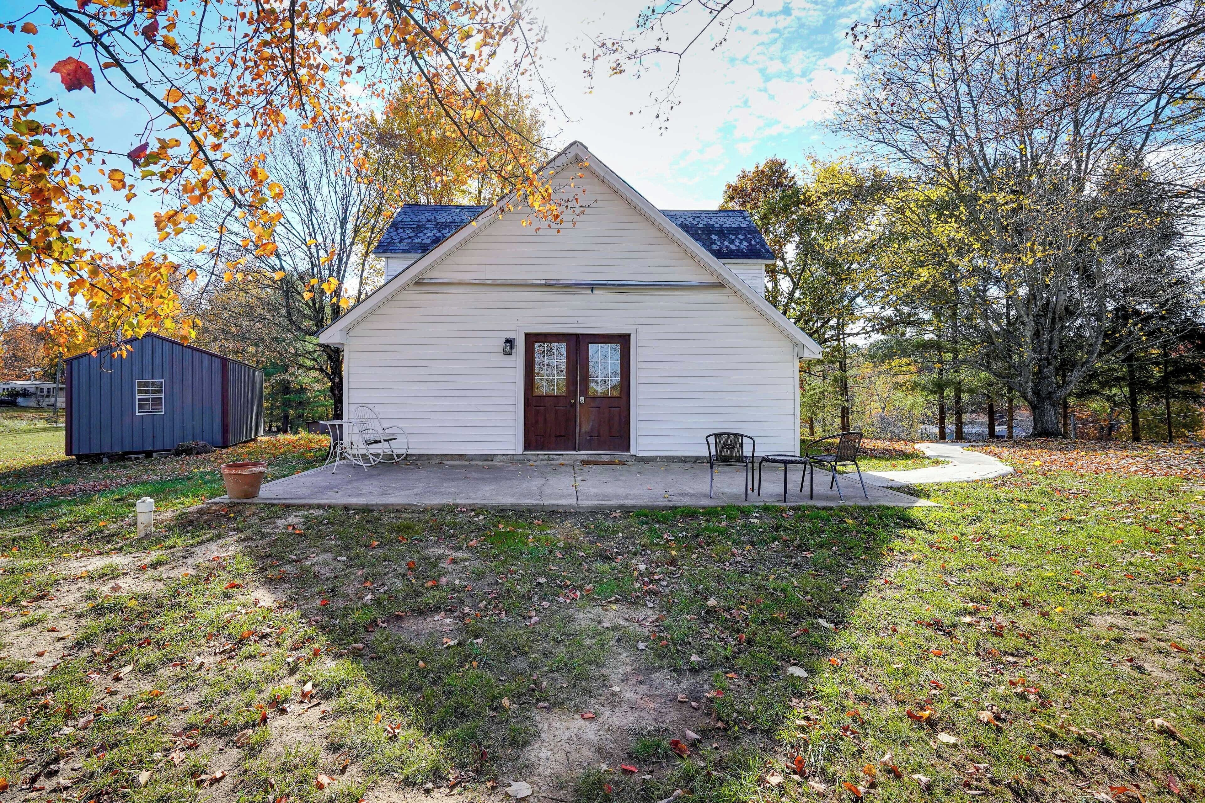 A small white building with a dark brown door and a small porch.