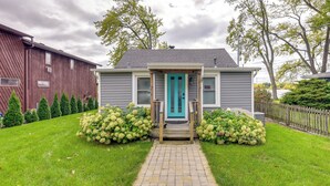 A house with a turquoise front door, a brick pathway leading to it, and a well-maintained lawn with hedges. - Lakefront Antioch Cottage w/ Dock & Gas Grill! (Antioch)