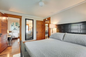 Un dormitorio con una cama grande, una puerta de madera y vistas a un comedor.