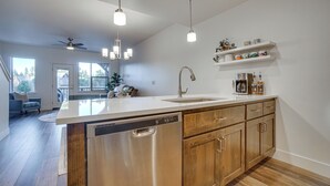 Een moderne keuken met een vaatwasser, houten kastjes en een aanrecht.