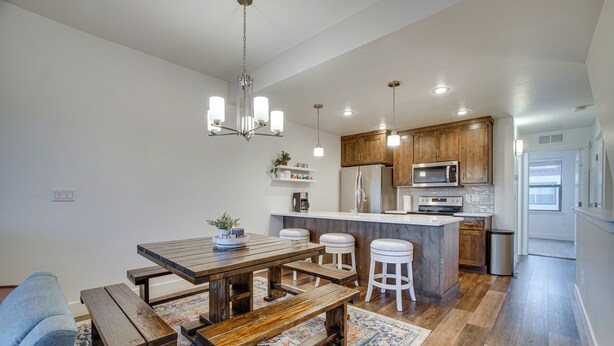 Een moderne keuken met houten kastjes, een centraal eiland en barstoelen.