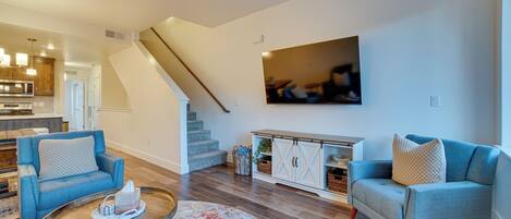 Una sala de estar moderna con un sofá, una mesa de centro y una escalera que sube a otro nivel.