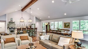 A spacious living room with a large sofa, a coffee table, and a dining area with a table and chairs.