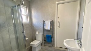 A bathroom with a glass-enclosed shower, a toilet, a towel rack, and a sink. - The Lady Hamilton B&B (Portsmouth)