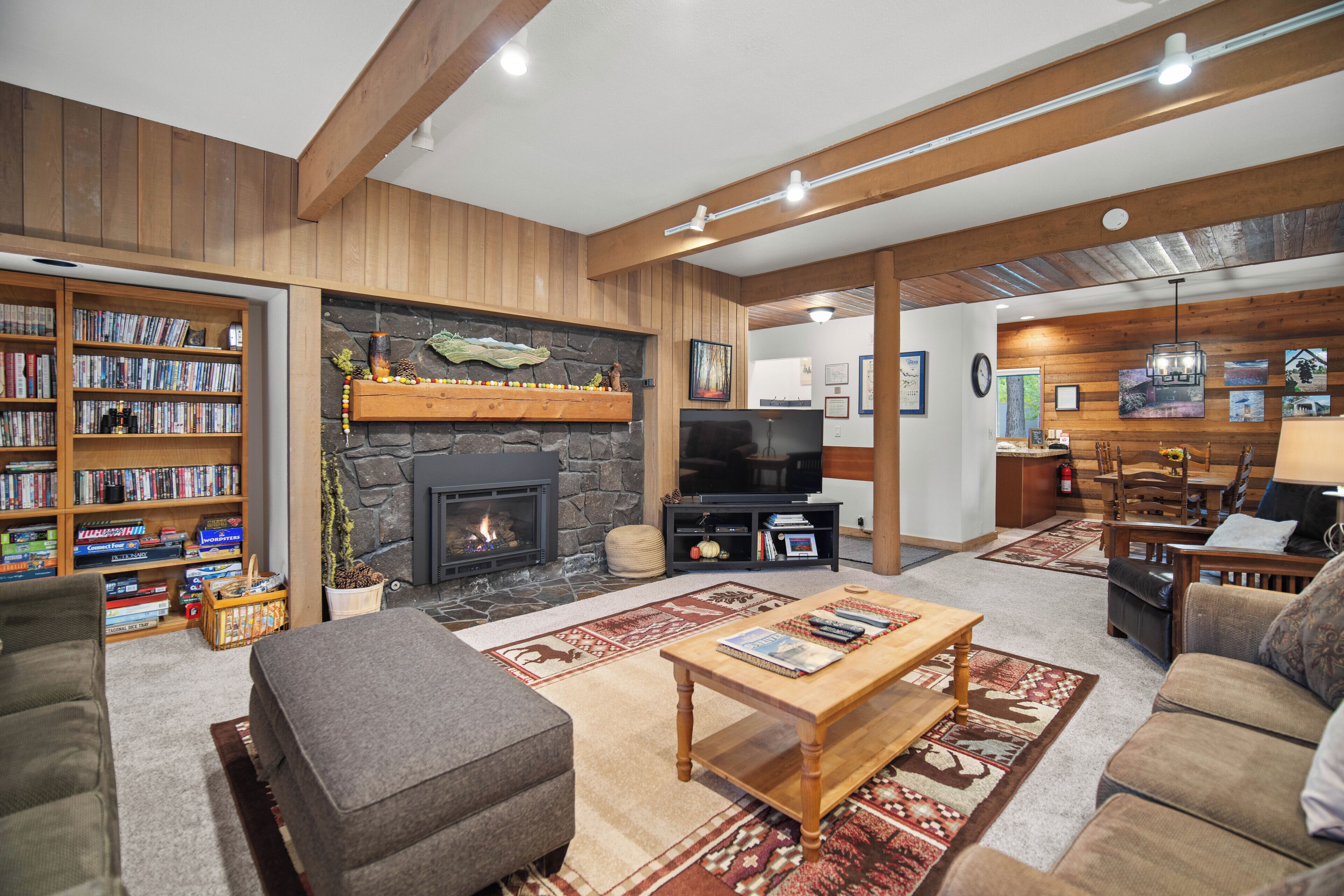 A cozy living room with a fireplace, bookshelves, a television, and comfortable seating.