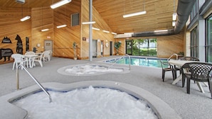 Une piscine intérieure dotée de plusieurs couloirs de nage, d’espaces pour s’asseoir et d’un décor intérieur en bois.