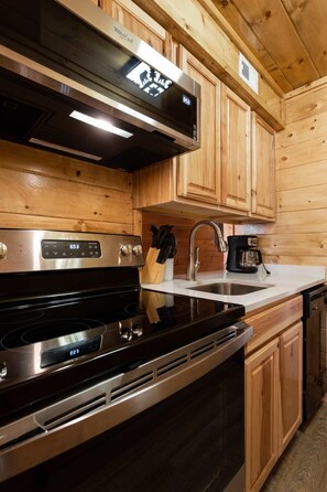 Una cocina moderna con electrodomésticos de acero inoxidable, armarios de madera y horno empotrado.