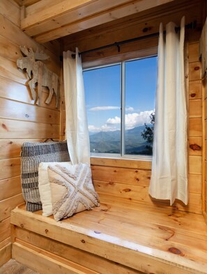 A wooden cabin room with a bench, a window with curtains, and a decorative moose head on the wall. - Huge Mt. LeConte View/Indoor Pool & HotTub/Updated (Gatlinburg)