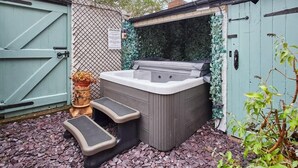 A spa hot tub with steps, a wooden fence, and a small potted plant. - Host & Stay | Allium House (Whitby)