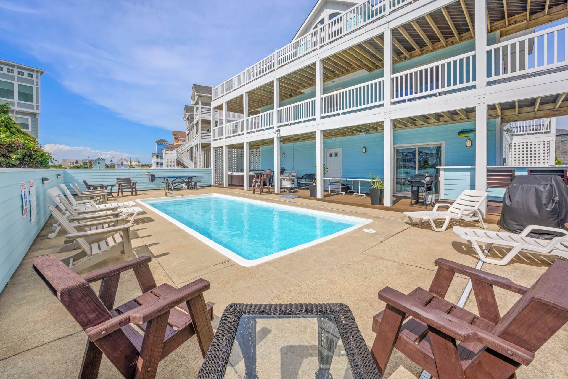 A rooftop pool area with lounge chairs and a covered seating area.