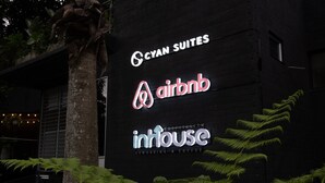 Ein Gebäude mit Schildern für 'Cyan Suites', 'Airbnb' und 'IntHouse'.