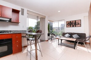 A modern apartment with a kitchen, dining area, and living room.