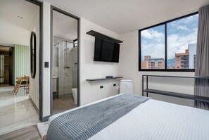 Relax in a spacious room with a large bed, flat-screen TV, and city views.