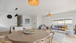 Ein moderner Wohnraum mit Essbereich, Küche und Sitzgelegenheit.