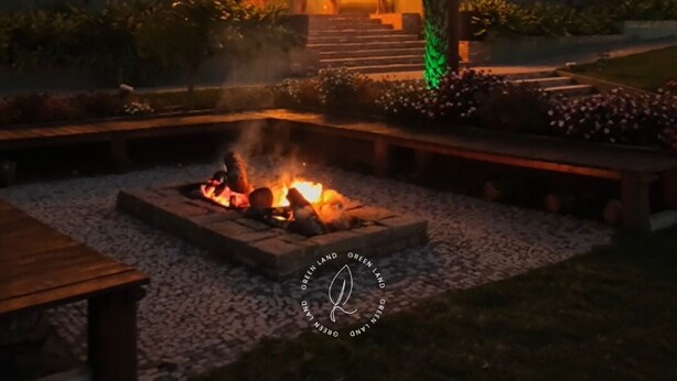 A building with a sign reading "ART GALLERY" at night, surrounded by a landscaped garden with a fire feature. -  Art Green (Teresópolis)
