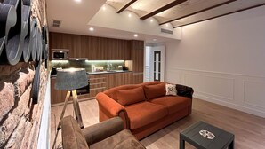 Una sala de estar moderna con un sofá, una mesa de centro y una cocina al fondo.