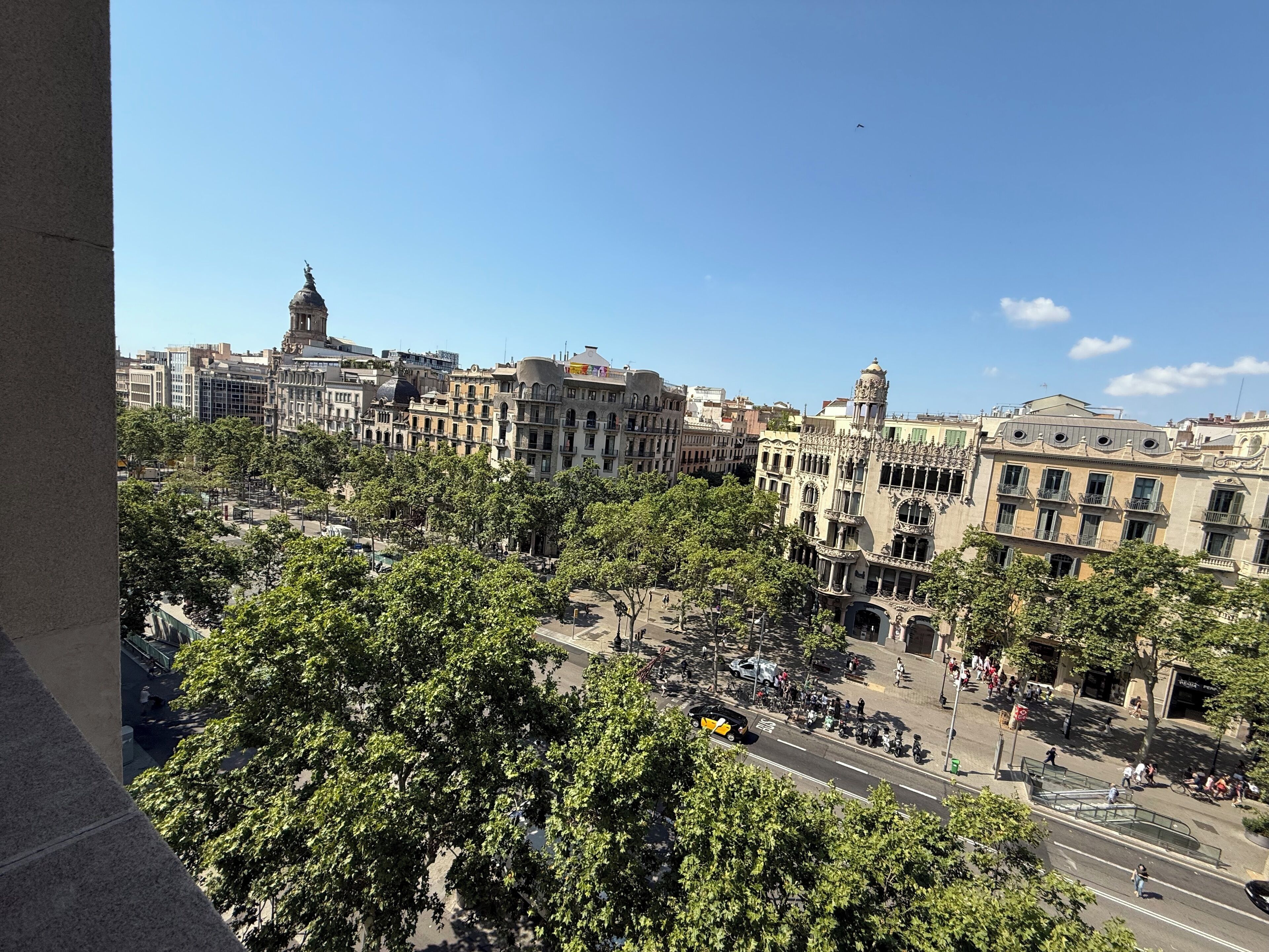 A cityscape with historic buildings, a prominent dome, and a busy street with pedestrians and vehicles.