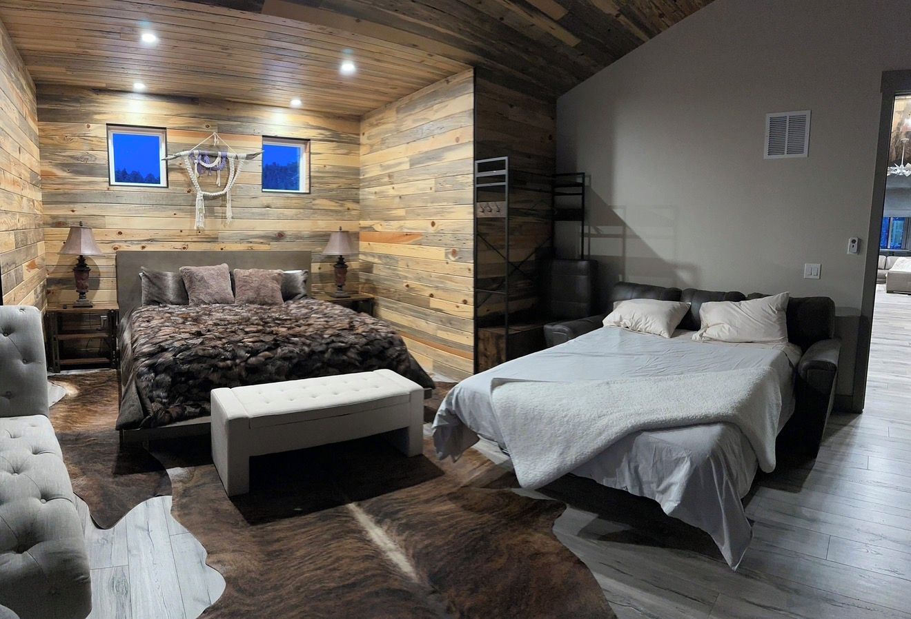 Ein Schlafzimmer mit zwei Betten, einer Bank und einer Pendelleuchte.