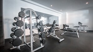 Ein Fitnessraum mit Krafttrainingsgeräten, Bänken und Kurzhanteln.