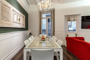 Enjoy meals in this elegant dining area with a large table, comfortable seating, and a beautiful chandelier.