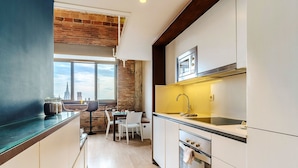 A modern kitchen with a large window, a brick wall, and a city view. - Enjoybcn Plaza Catalunya Apartment (Barcelona)